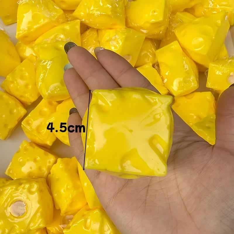 A hand holds a bright yellow crunchy cheese stress ball fidget toy with a black line marking its size.