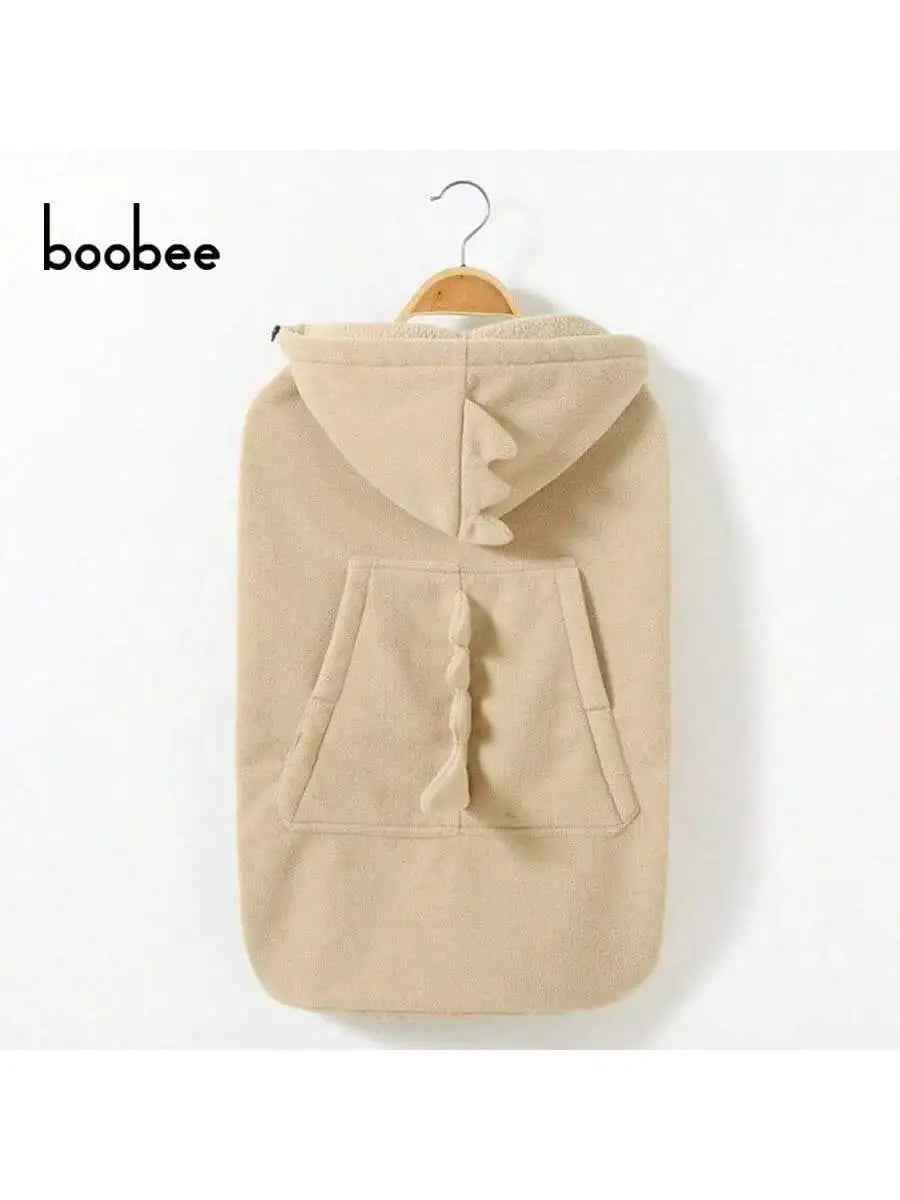 A beige baby windproof cape blanket featuring a dinosaur design, displayed on a hanger.