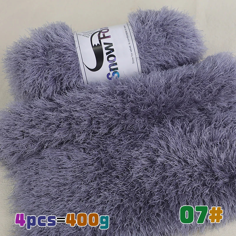 A close-up of a fluffy gray faux fur yarn bundle with a label showing the brand SnowFo