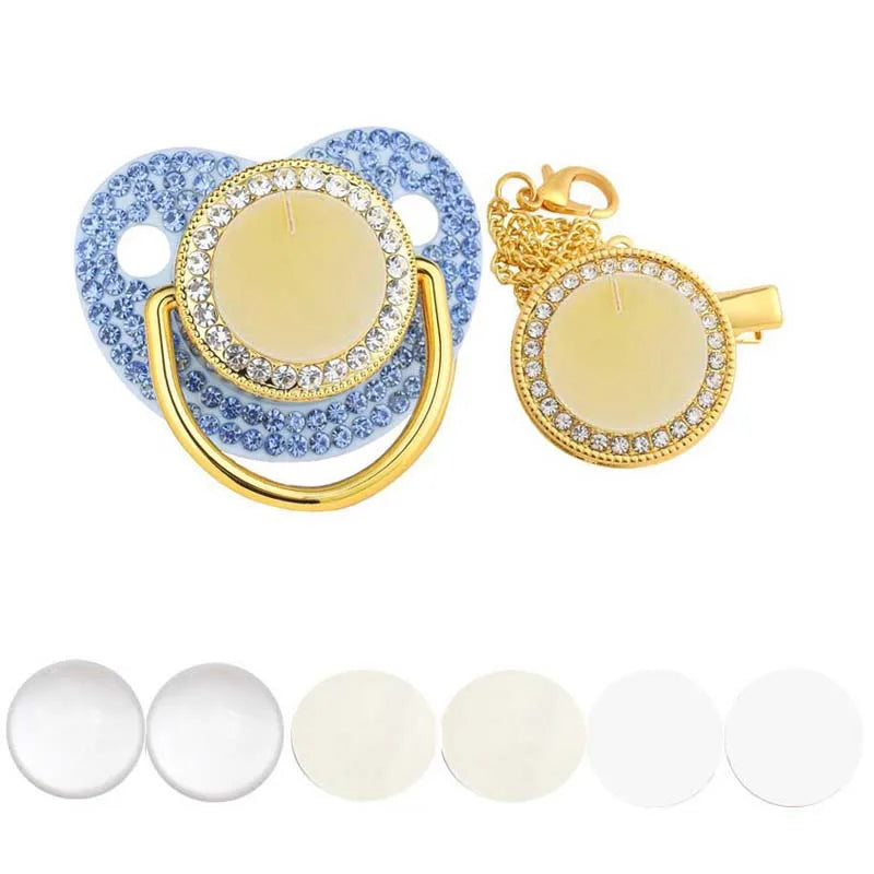 A set of baby pacifiers and clips featuring blue and gold rhinestone accents.