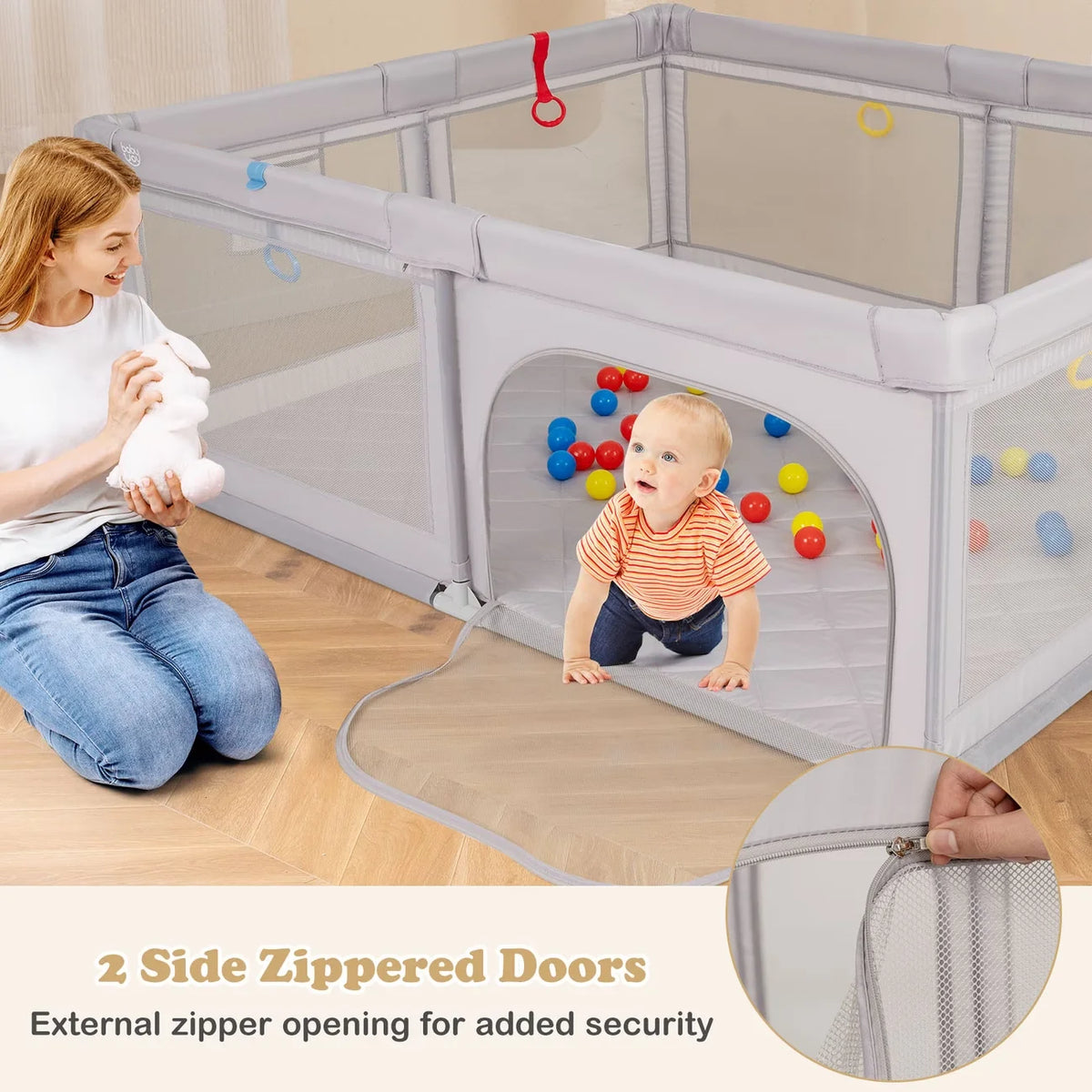 A baby is playing inside a large gray playpen with two zippered doors, demonstrating external zipper opening for added securi