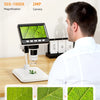 A man is examining a leaf under a portable digital microscope with various magnification levels displayed on the screen.