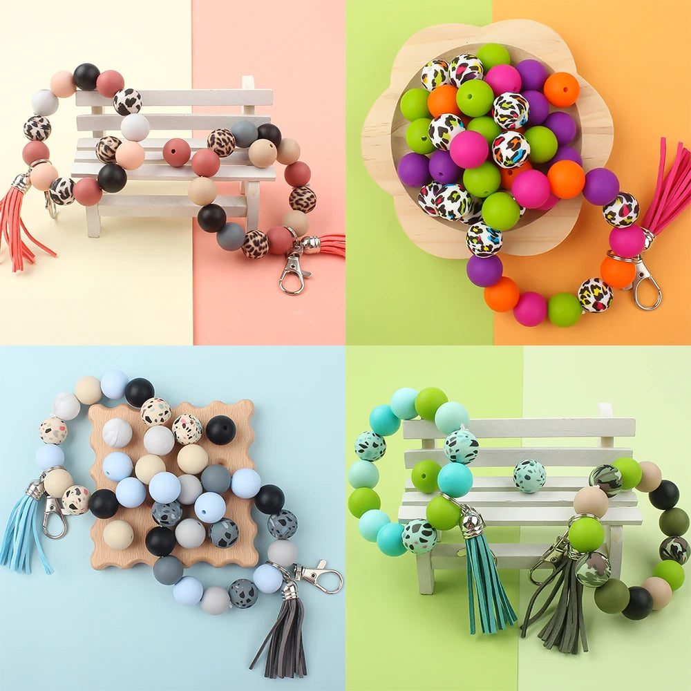 Assortment of printed silicone beads in leopard and daisy patterns for jewelry making, displayed on wood and fabric.