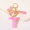 Gold initial heart keychain featuring a pink butterfly charm and pink tassel.