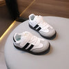 A pair of white and black casual sneakers resting on a light surface.