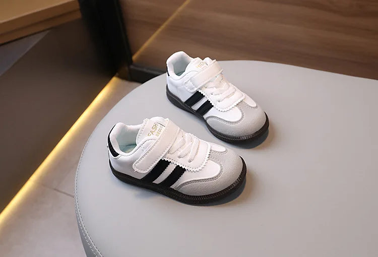 A pair of white and black casual sneakers resting on a light surface.
