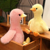 A pink and yellow realistic call duck plush toy with a yellow beak sitting on a wooden surface.