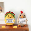 A handmade crochet owl doll with a colorful wreath and inspirational text on its chest.