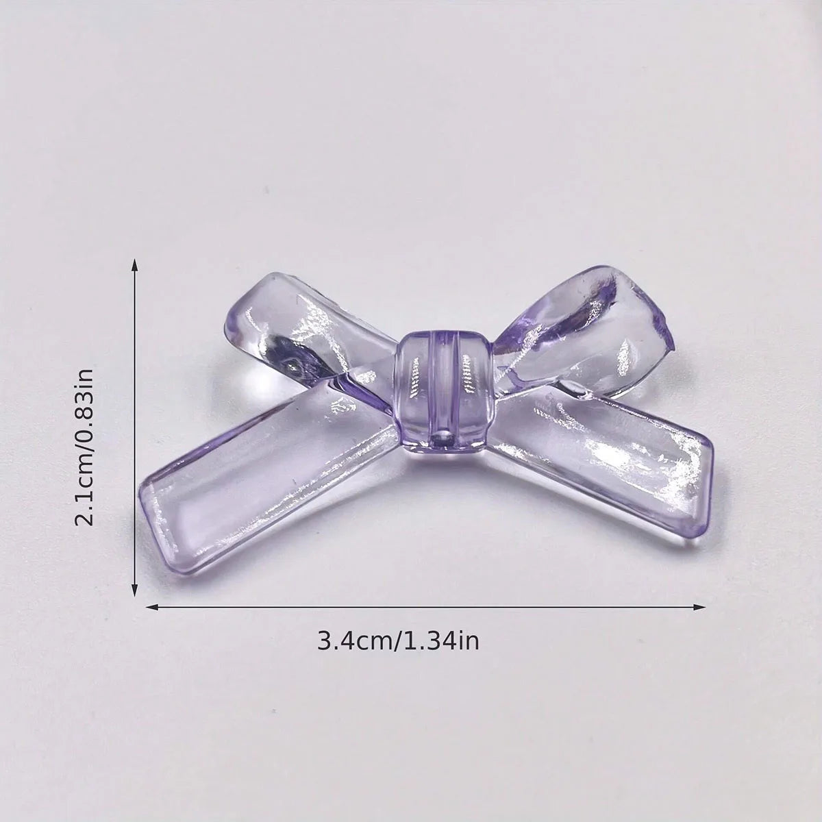 A clear purple acrylic bow tie bead shown with its dimensions.