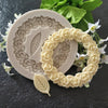 A silicone mold featuring rosette leaves and a wreath design for cake and chocolate decorating.