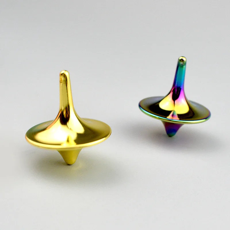 A metal fidget spinner with a smooth, golden-yellow top and disc, showing iridescent colors.
