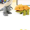 Un mini doigt dinosaure gris à côté d'un jouet dinosaure texturé orange et vert.
