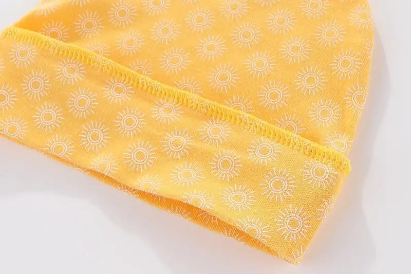 Yellow long-sleeve baby shirt with a white sun pattern