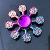 A colorful metal fidget spinner with a purple center and rose-shaped blades.
