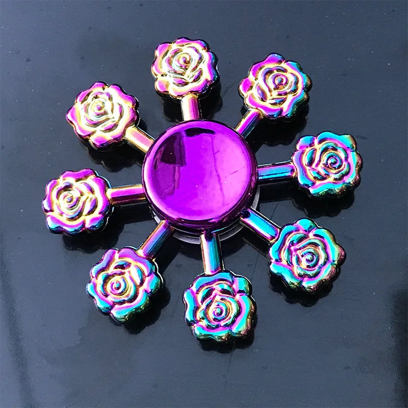 A colorful metal fidget spinner with a purple center and rose-shaped blades.