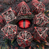 A collection of red and black metal dice shaped like dragons and geometric solids for tabletop role-playing games