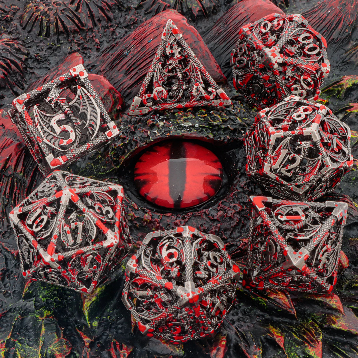 A collection of red and black metal dice shaped like dragons and geometric solids for tabletop role-playing games