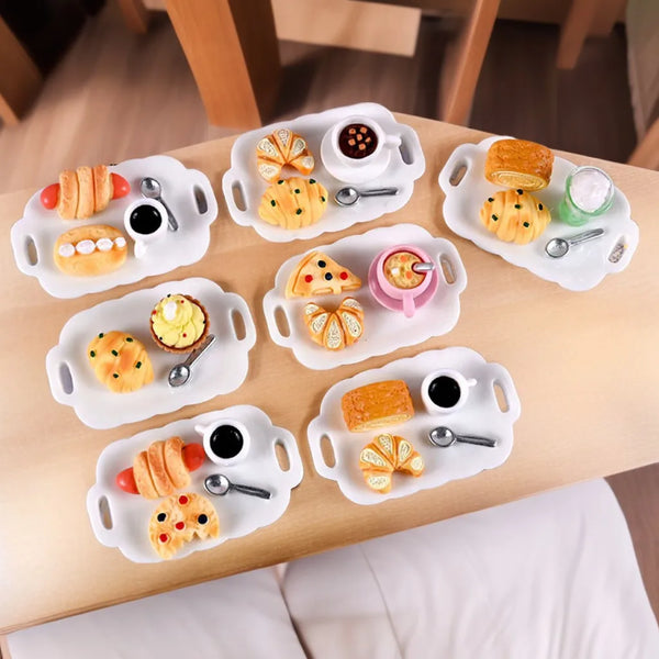 A wooden tray holds various small pastries and tea items arranged on white ceramic plates for an afternoon tea set.