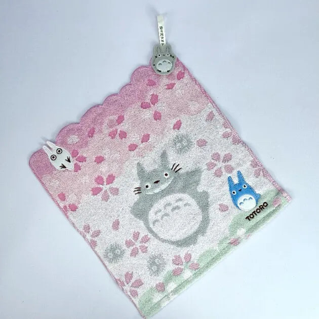 A pink plush toy featuring a cute cat design and a small blue animal on a white background.