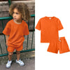 An orange kids summer tracksuit set featuring a short sleeve top and matching shorts.