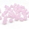 A pile of faceted pink bicone crystal glass beads for jewelry making