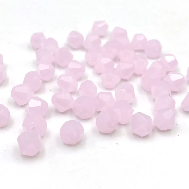 A pile of faceted pink bicone crystal glass beads for jewelry making