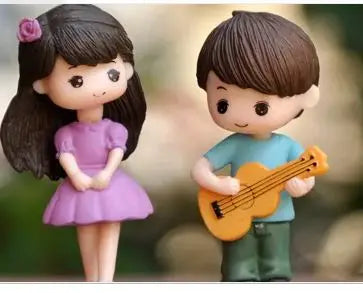 Two musical couple figurines, a girl and a boy, in purple and blue, for cake or decor.
