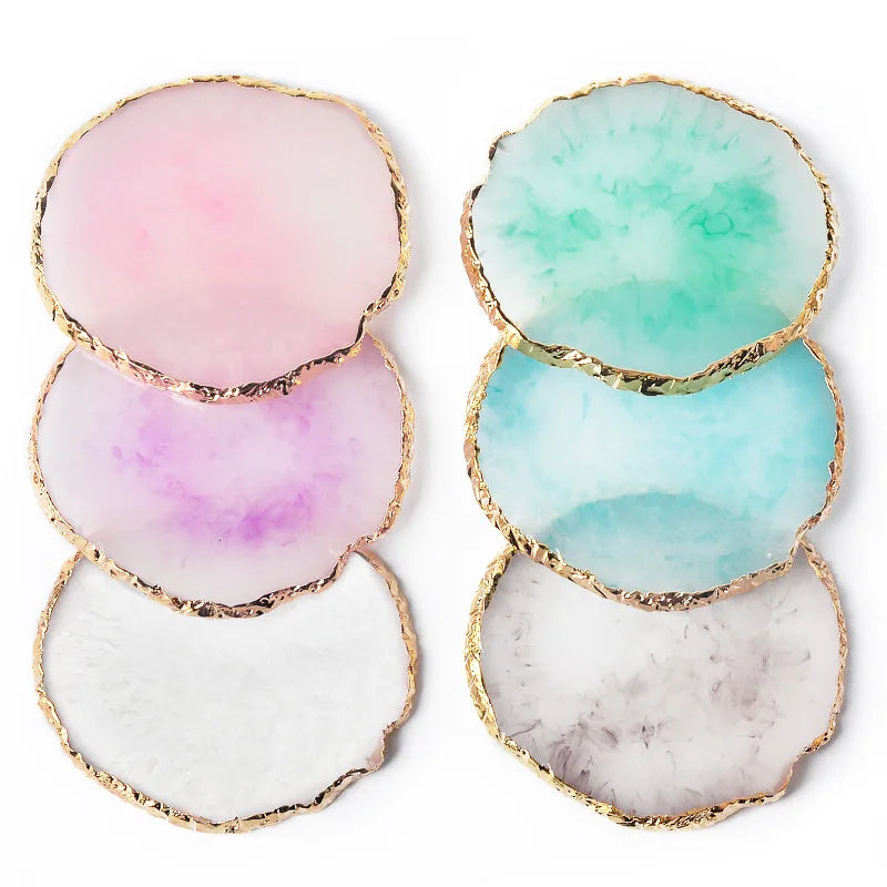 A set of five round resin nail art palettes with gold trim in shades of pink, green, and white.