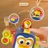 A hand is pushing a button on a blue and yellow sensory toy featuring a pop-up puppy.
