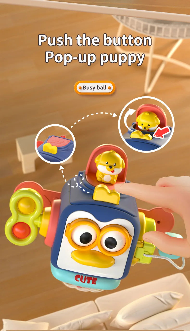 A hand is pushing a button on a blue and yellow sensory toy featuring a pop-up puppy.