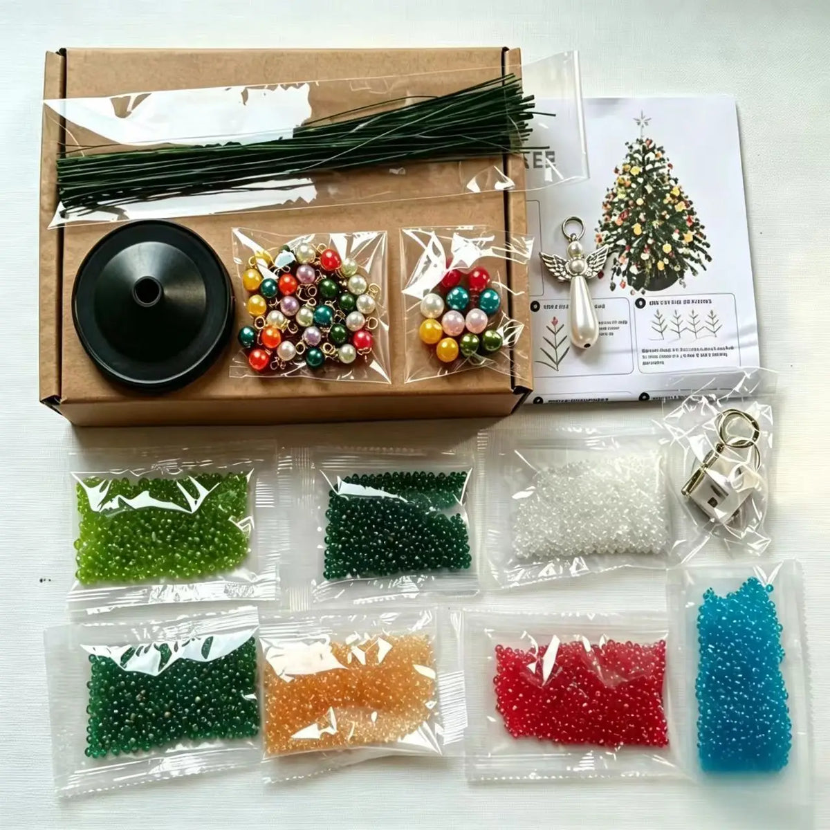 A DIY beaded Christmas tree kit showing various colored beads and a small tree decoration.