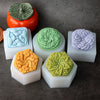 A collection of flexible silicone flower molds in various colors, including orange, blue, green, and purple, displayed on a d