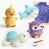 A set of seven crocheted amigurumi animals including a yellow duck, a blue fish, a light blue creature, and a purple owl, wit