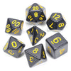 A collection of black acrylic dice showing various numbers and shapes used for tabletop role-playing games