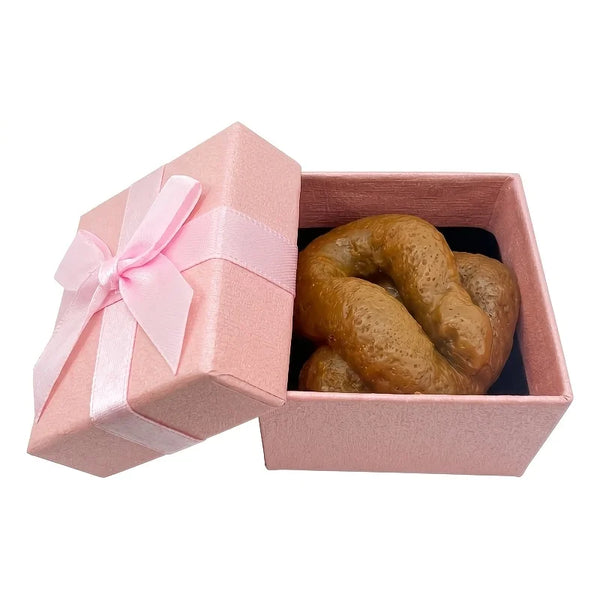 A loaf of bread is placed inside a pink gift box tied with a pink ribbon.