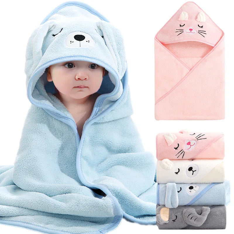 A soft light blue hooded towel featuring a cat design, shown alongside folded towels in pink and gray tones.