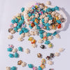 A collection of multicolor ocean turtle beads scattered on a white surface.