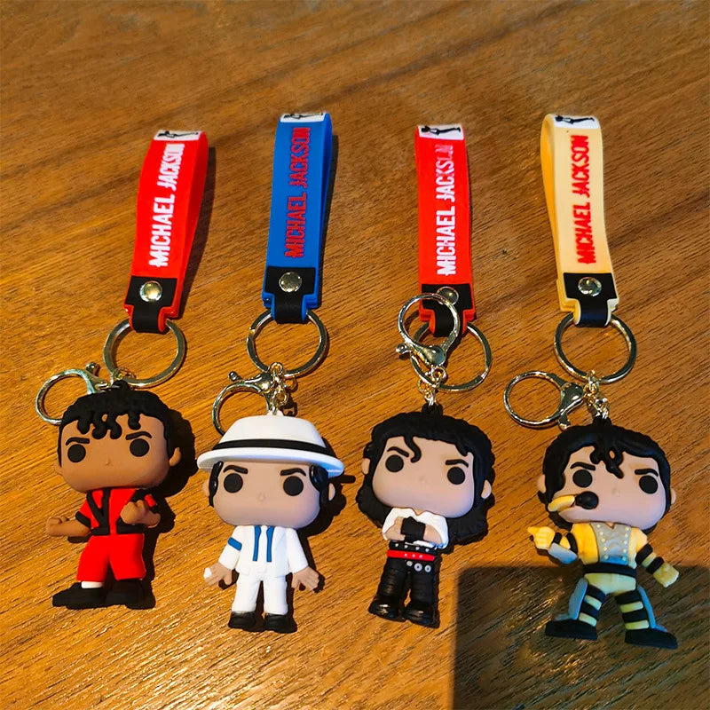 Four keychains featuring Michael Jackson dance poses in red, blue, and yellow.