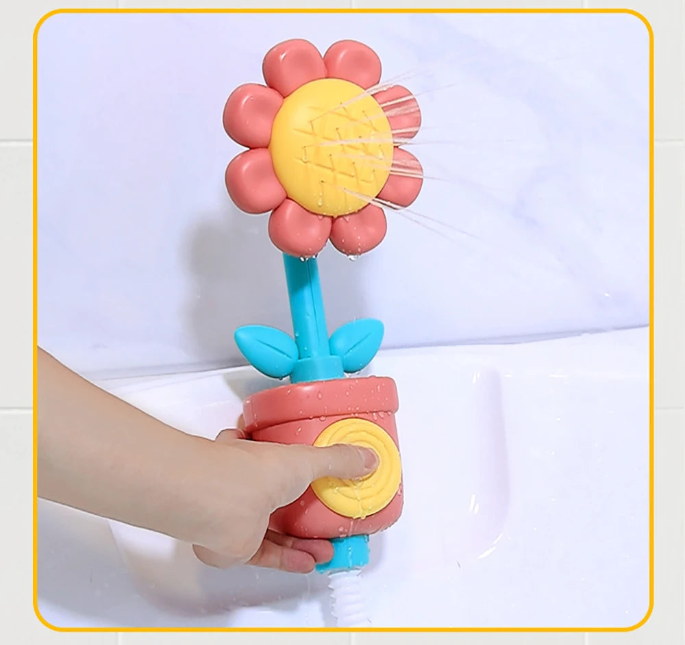 A hand is holding a colorful sunflower bath shower sprinkler toy for kids with pink and yellow flower shapes.