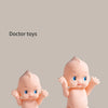 A pair of pink baby doctor toys, including a baby figure and accessories, are displayed against a neutral background.