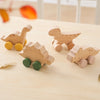 Wooden dinosaur teether toy car in natural wood tones and yellow and green wheels