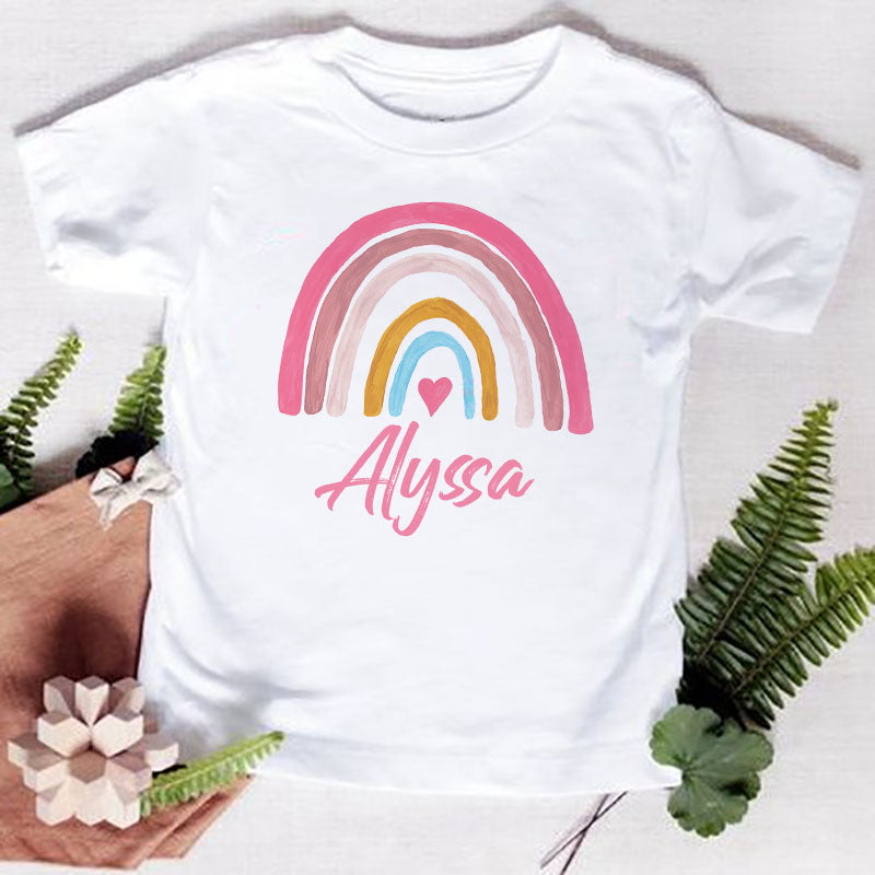 White t-shirt featuring a pink and yellow rainbow arch design and the name Alyssa in pink script