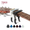 A set of seven guitar capo pieces including picks and a holder displayed on a wooden guitar neck.