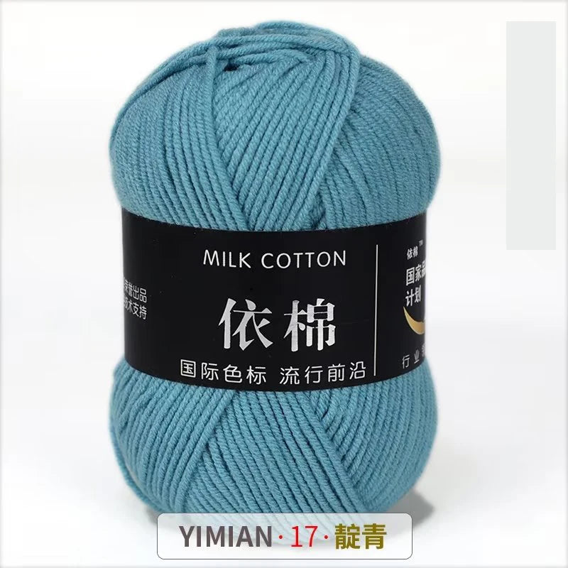 A skein of teal milk cotton yarn with a black label featuring Chinese characters and the brand name YIMIAN