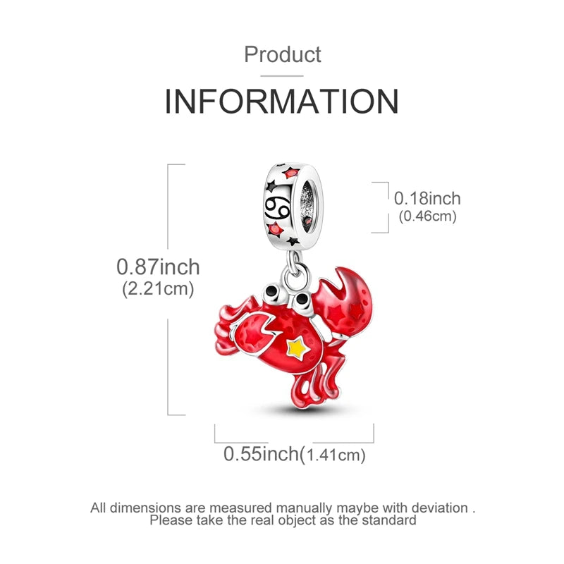 A silver heart charm with a dragon design is shown next to a ruler for scale.