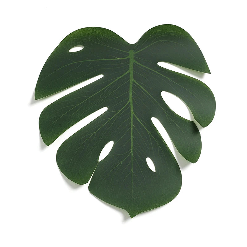 A vibrant green artificial tropical palm and monstera leaf used for party decor.