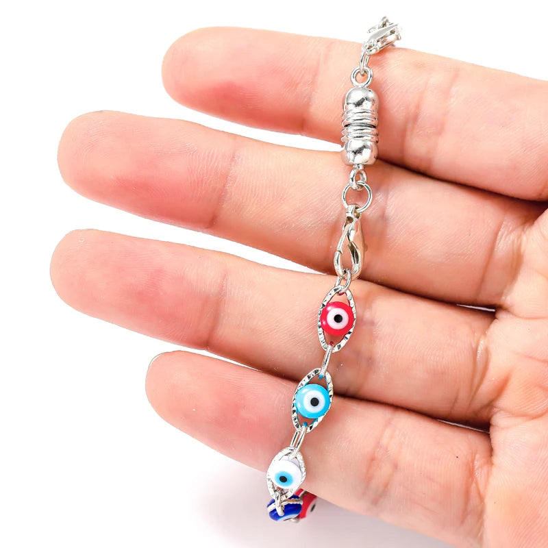 A hand holds a silver magnetic lobster claw clasp jewelry component for making jewelry