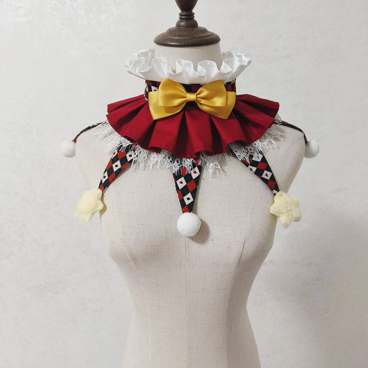 A vintage clown ruff collar accessory featuring a red and black checkered fabric with a yellow bow and white trim.