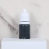 A black dropper bottle with a white cap sits on a white surface.