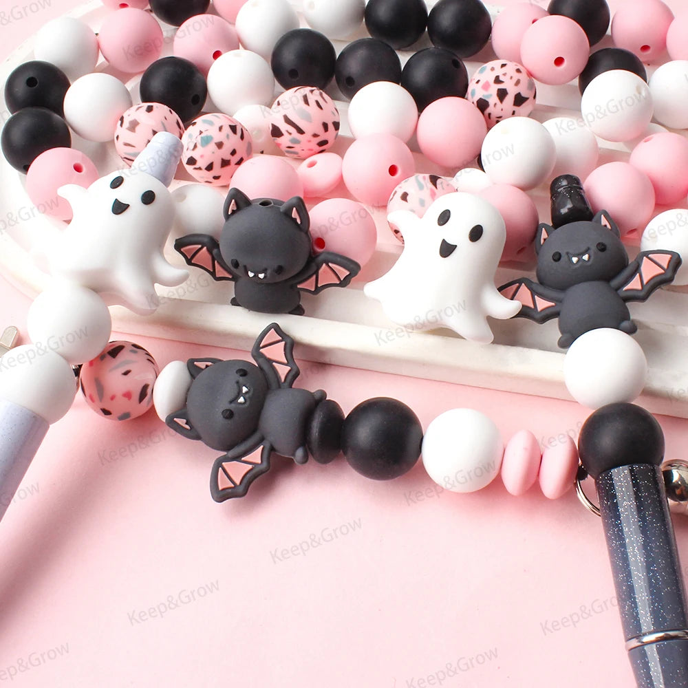 A collection of pink and black silicone craft beads arranged on a white surface.